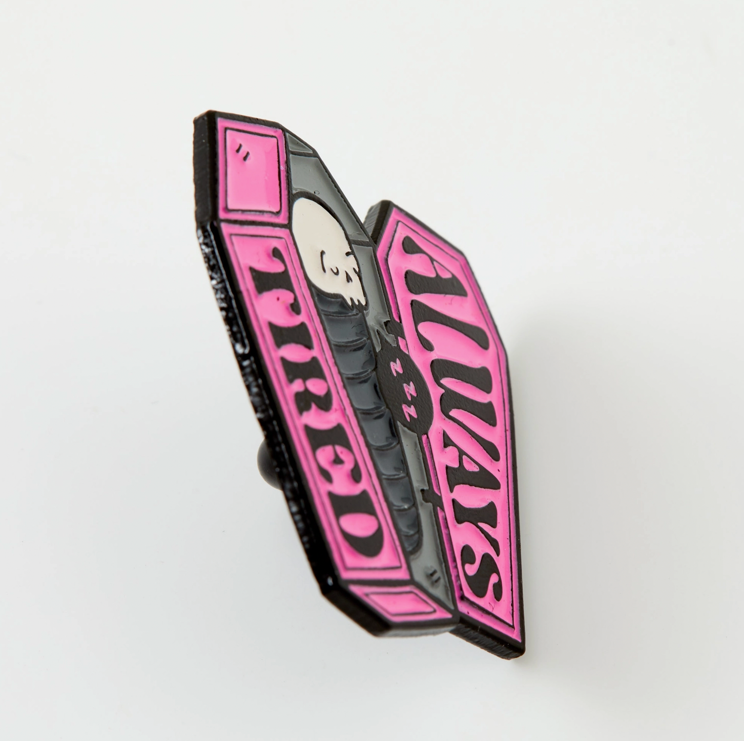 a close up of a pink and black brooch